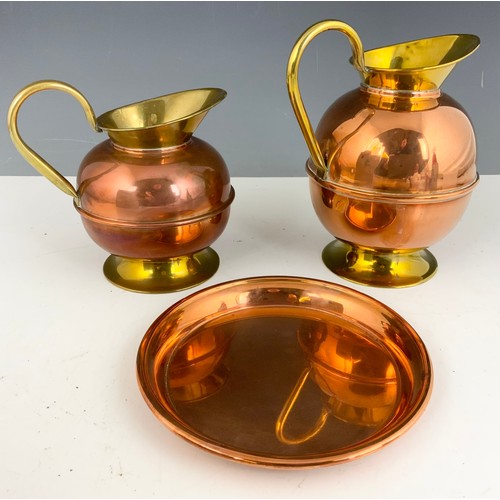 317 - A PAIR OF BRASS AND COPPER JUGS AND A COPPER PLATE