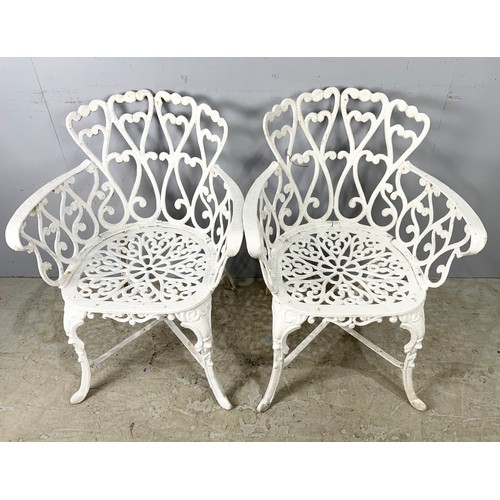 565 - TWO CAST 2 GARDEN CHAIRS WITH A SIMILAR TABLE 80cm DIAMETER