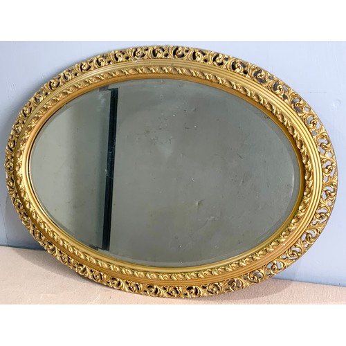 69 - OVAL BEVELED MIRROR IN ORNATE GILT FRAME  88cm x 63cm