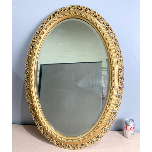 69 - OVAL BEVELED MIRROR IN ORNATE GILT FRAME  88cm x 63cm