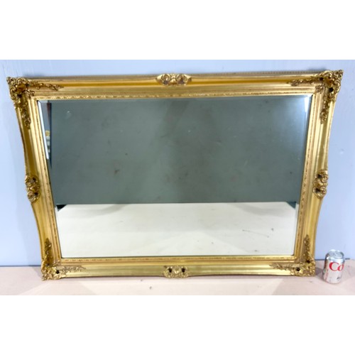 76 - MODERN BEVELVED MIRROR IN ORNATE GILT WOOD FRAME  105cm x 74cm