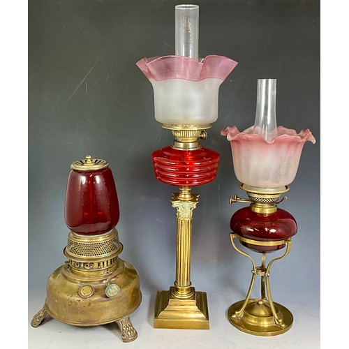 306 - Withdrawn 2 LATE 19TH/EARLY 20TH CENTURY BRASS LAMPS WITH RED OR CRANBERRY GLASS, BOTH WITH FLARED O... 