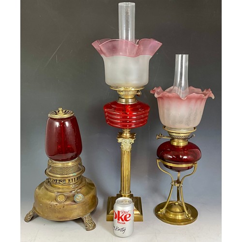 306 - Withdrawn 2 LATE 19TH/EARLY 20TH CENTURY BRASS LAMPS WITH RED OR CRANBERRY GLASS, BOTH WITH FLARED O... 