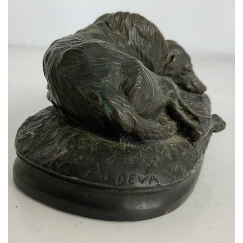 287 - A COMPOSITE BRONZE MODEL OF A RECUMBENT WOLF HOUND, SIGNED M DEVA WIDTH 15CM