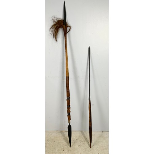 403 - TWO TRIBAL SPEARS . ONE HAS A BLADE AT BOTH ENDS WITH ANIMAL FUR& CARVED DECORATION LONGEST  157cm