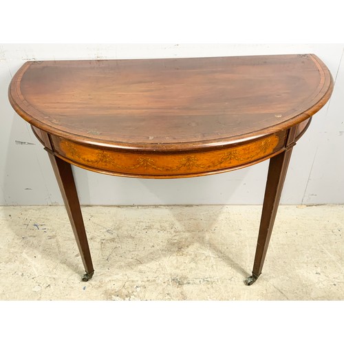 553 - MAHOGANY D END SIDE TABLE WITH INLAID SWAG  & RIBBON DECORATION ON BRASS CASTERS  WIDTH 107cm