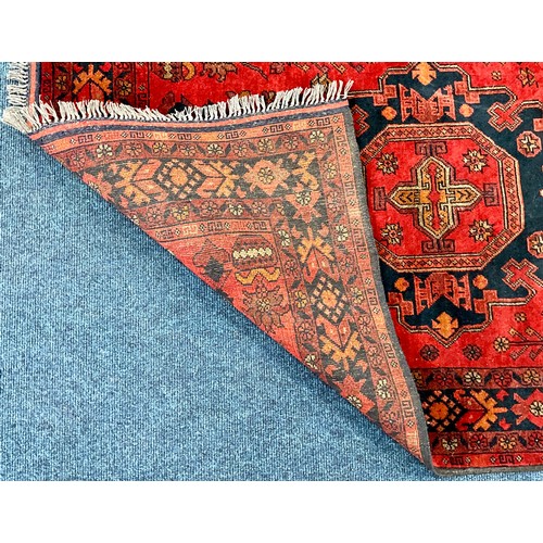 703 - AN AFGHAN RED GROUND RUG. 155 X 103cm Approx.