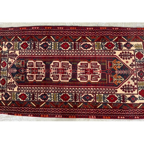 690 - RED GROUND RUG WITH GEOMETRIC PATTERN 185cm x 97cm