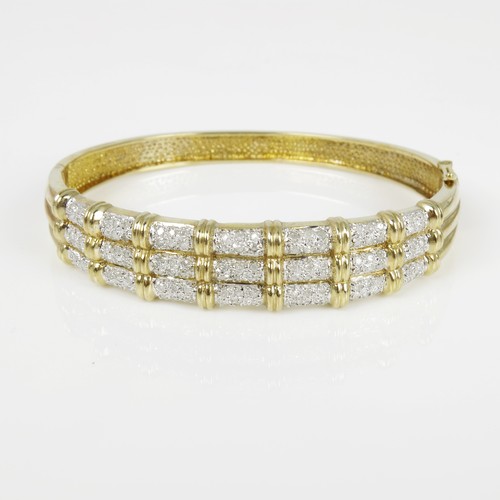 574 - 9CT GOLD AND WHITE STONE HINGED BANGLE