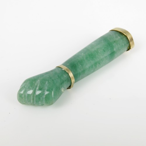 563 - VARIEGATED JADE PENDANT IN THE FORM OF AN ARM AND FIST IN YELLOW METAL MOUNT