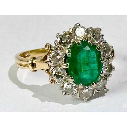 684 - DIAMOND AND EMERALD CLUSTER RING FEATURING AN OVAL CUT EMERALD APPROX. 9.7 X 7.9 mm WITHIN A RING OF... 