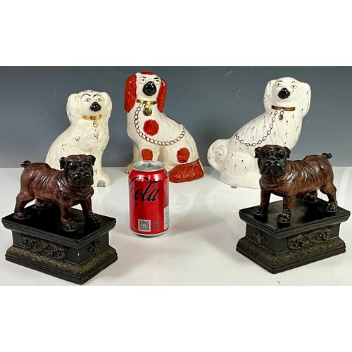 127 - THREE STAFFORDSHIRE DOG FIGURES AND PAIR OF BULLDOGS ON PLINTHS