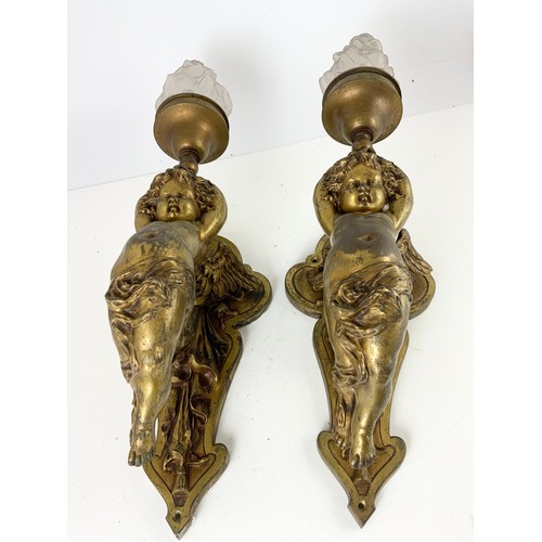 295 - PAIR OF METAL WALL LIGHT FITTINGS MODELLED AS CHERUBS WITH GLASS FLAME SHAPED SHADES