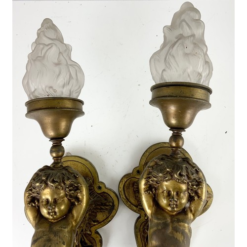 295 - PAIR OF METAL WALL LIGHT FITTINGS MODELLED AS CHERUBS WITH GLASS FLAME SHAPED SHADES