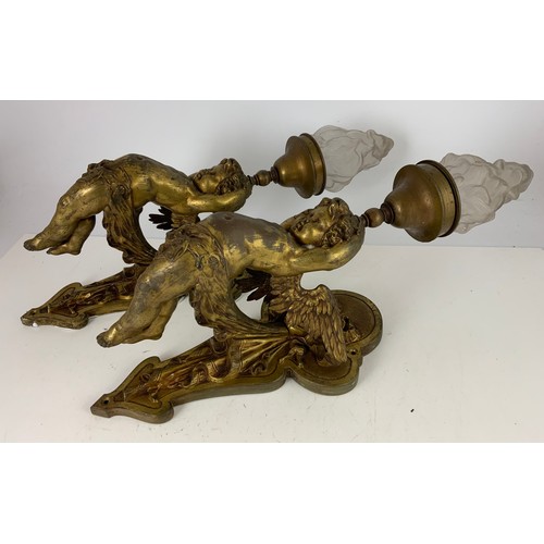 295 - PAIR OF METAL WALL LIGHT FITTINGS MODELLED AS CHERUBS WITH GLASS FLAME SHAPED SHADES