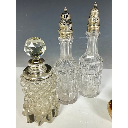 307 - CUT GLASS AND DOULTON LAMBETH CRUETS MOST WITH HALLMARKED SILVER LIDS