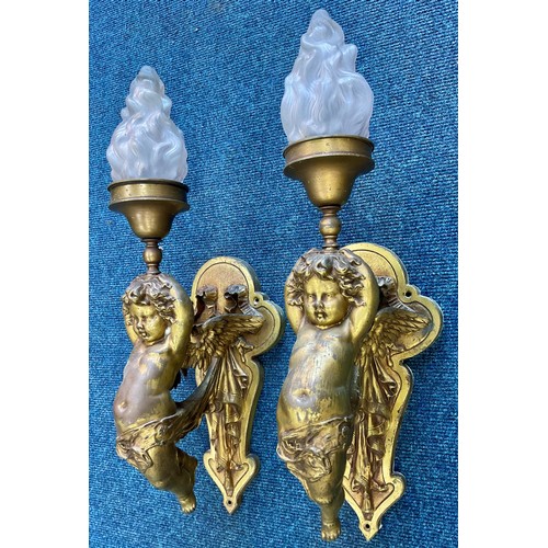 295 - PAIR OF METAL WALL LIGHT FITTINGS MODELLED AS CHERUBS WITH GLASS FLAME SHAPED SHADES