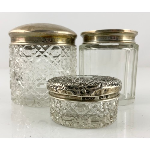 288 - GLASS HAIR TIDY WITH SILVER TOP, DRESSING TABLE POT WITH EMBOSSED SILVER COVER AND ON OTHER WITH SIL... 