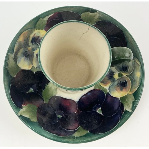 18 - RARE EARLY MOORCROFT POTTERY COFFEE CAN / CUP AND SAUCER DECORATED WITH PANSY PATTERN ON A WHITE  GR... 