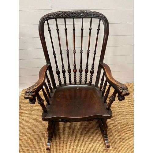 118 - A Windsor rocking chair with turned spindles and carved foo dogs handles (H96cm W68cm)