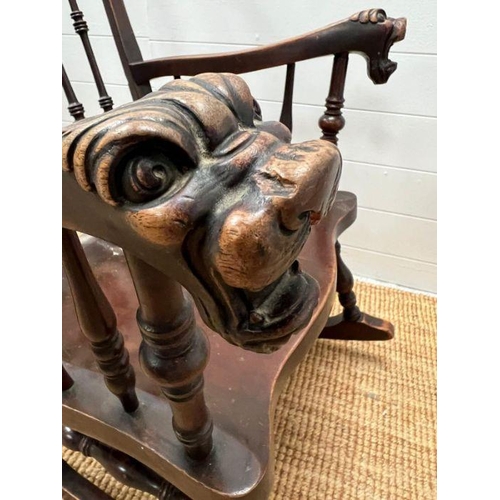 118 - A Windsor rocking chair with turned spindles and carved foo dogs handles (H96cm W68cm)