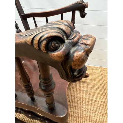 118 - A Windsor rocking chair with turned spindles and carved foo dogs handles (H96cm W68cm)