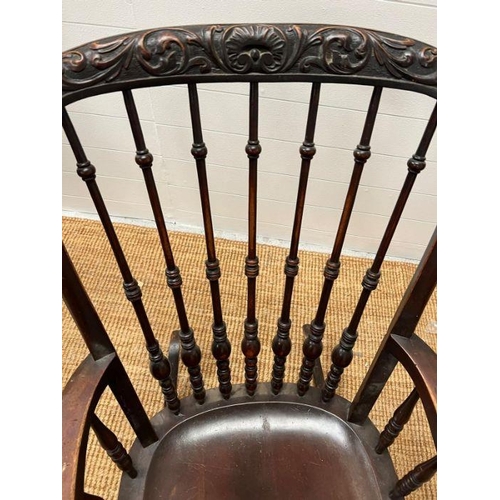118 - A Windsor rocking chair with turned spindles and carved foo dogs handles (H96cm W68cm)
