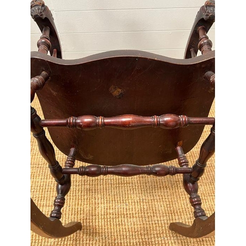 118 - A Windsor rocking chair with turned spindles and carved foo dogs handles (H96cm W68cm)