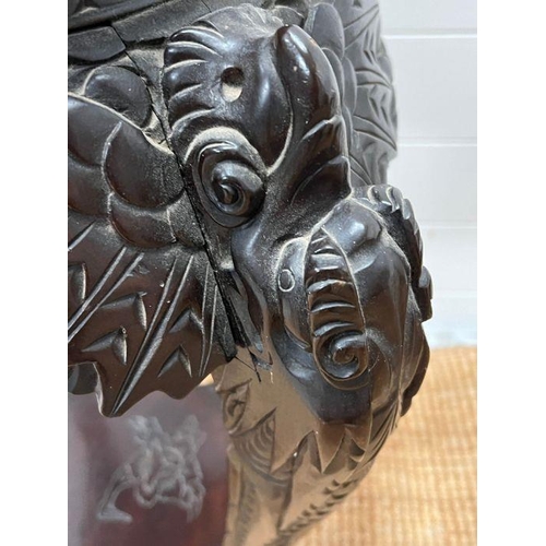 125 - An ebonised plant stand table, carved with leaves and flowers (H73cm)