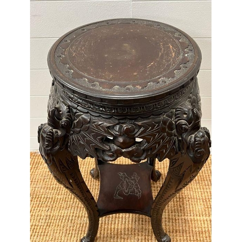 125 - An ebonised plant stand table, carved with leaves and flowers (H73cm)