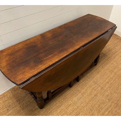 132 - A large drop leaf table on turned legs (160 cm x 153cm max)