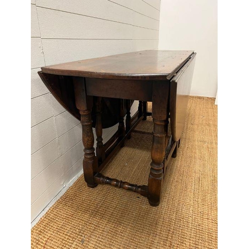 132 - A large drop leaf table on turned legs (160 cm x 153cm max)