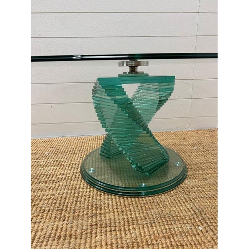 133 - A glass coffee table with two central fan glassed columns. 120cm L x 45cm H)