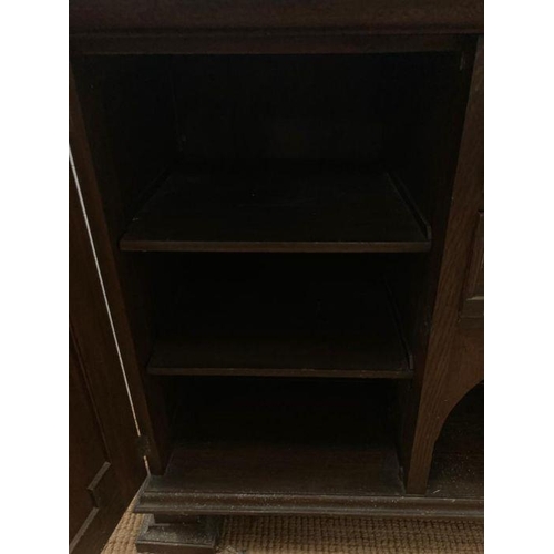 134 - An Arts and Crafts style sideboard, two central drawers flanked by cupboards on square turned feet (... 