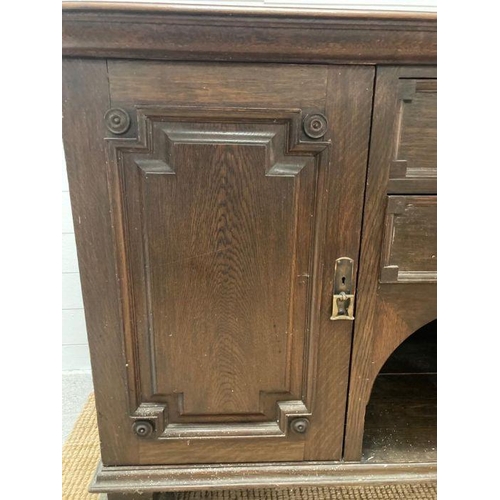 134 - An Arts and Crafts style sideboard, two central drawers flanked by cupboards on square turned feet (... 