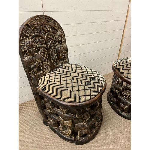 139 - A pair of carved seats with tribal theme carving to back and base