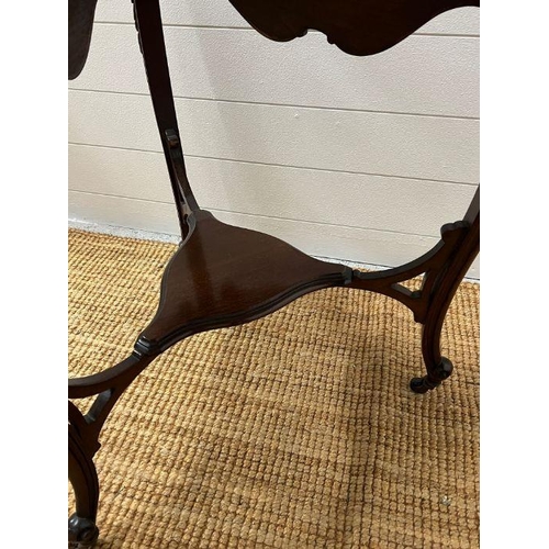 150 - A tri-form side table with scrolling edges and legs terminating on castors