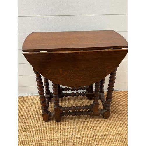 164 - An oak gate leg table with drawer to centre