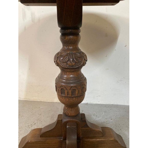 175 - An oak side table on carved central support (H59cm Dia56cm)