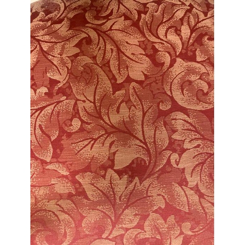 176 - An oak spool turned ladder back arm chair upholstered in red