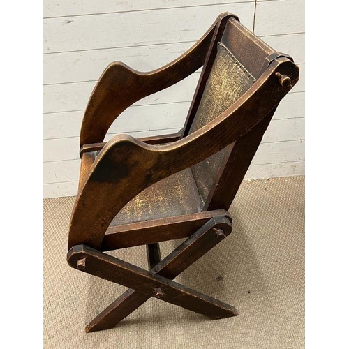 258 - A solid oak Tudor Revival Glastonbury chair, with shaped arms and x frame legs with joints held with... 