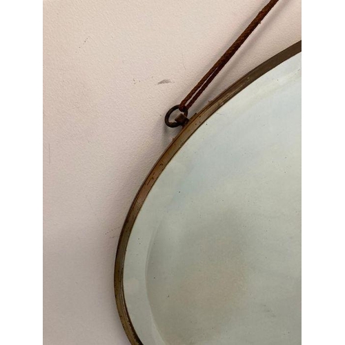 321 - An oval brass framed Arts and Crafts style bevel edged mirror