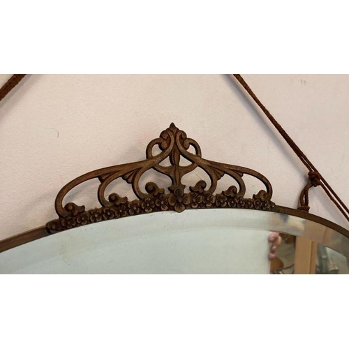 321 - An oval brass framed Arts and Crafts style bevel edged mirror