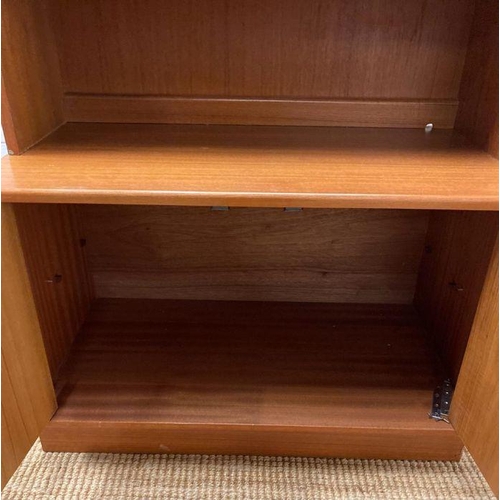 66 - A G-Plan wall unit with two glazed doors and three shelves to top and a two door cupboard to bottom ... 