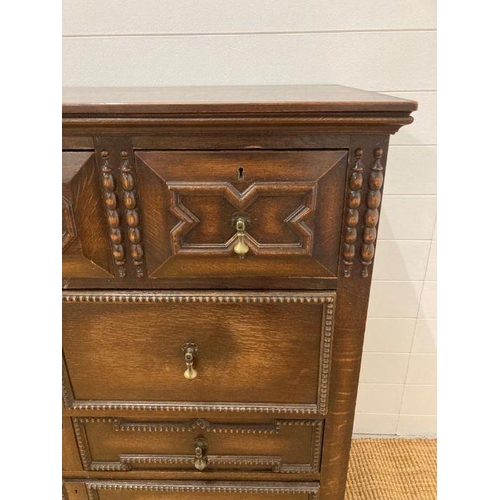 68 - An oak Jacobean style three over three chest of drawers with central drop down front (H110cm W107cm ... 