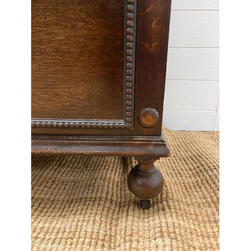 68 - An oak Jacobean style three over three chest of drawers with central drop down front (H110cm W107cm ... 