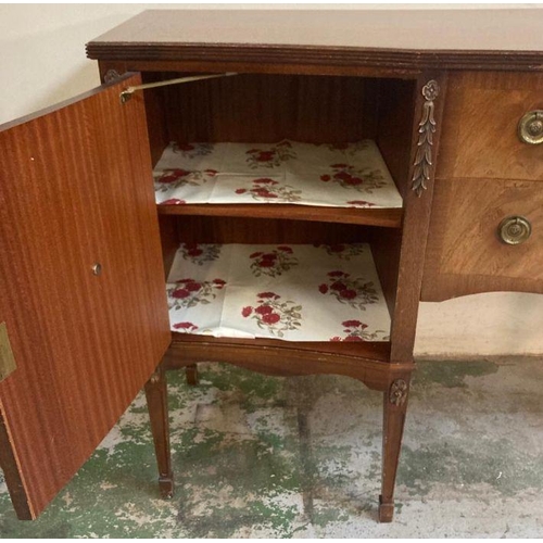 139 - A mahogany serpentine fronted sideboard, two drawers flanked by cupboards and ornate floral carving