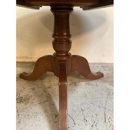 140 - A mahogany oval pedestal dining table on tripod legs (H77cm W120cm D50cm)