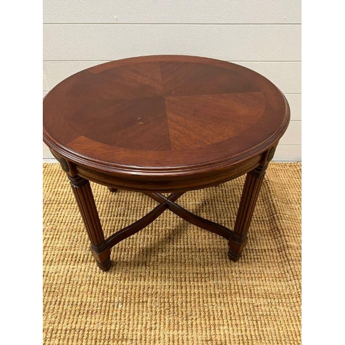 174 - A circular side table on fluted legs and cross stretchers (H54cm W67cm D58cm)