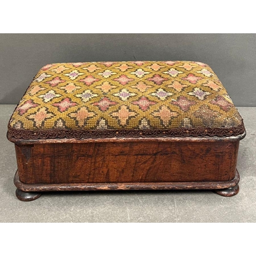 184 - A mahogany Victorian footstool with needle point on bun feet opening to storage